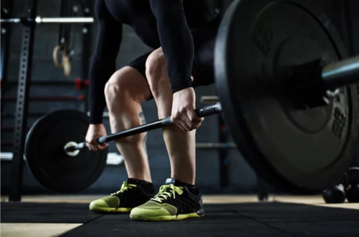 a man beings a barbell deadlift