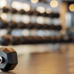 a hex headed dumbbell sits alone on the gym floor