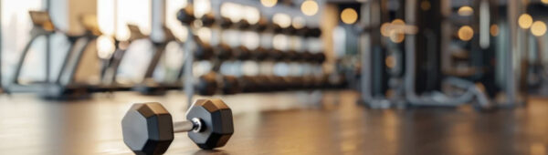 a hex headed dumbbell sits alone on the gym floor